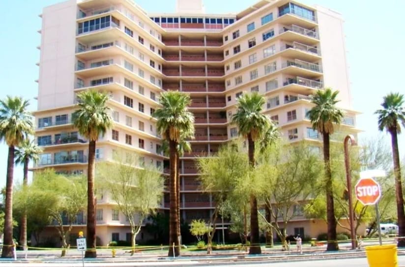 A large building with palm trees in front of it.