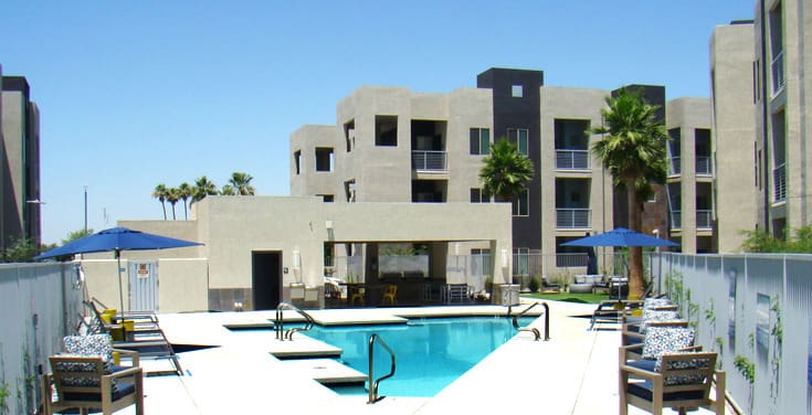 A pool with a large building in the background.