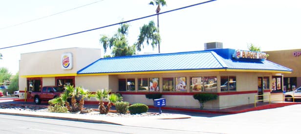 A blue and yellow building with trees in the background