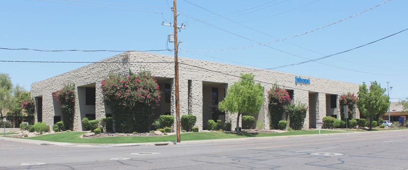 A building with trees and power lines in front of it.