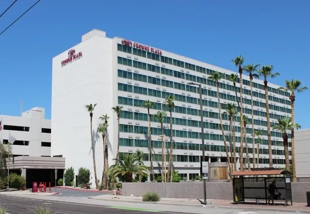 A large hotel with palm trees in front of it.